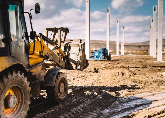 close up details of massive heavy duty machinery, industrial backhoe loader with excavator on construction site